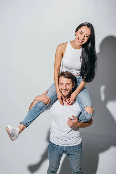 Jovem Homem Segurando Namorada Nos Ombros Enquanto Sorrindo Olhando Para — Fotografia de Stock