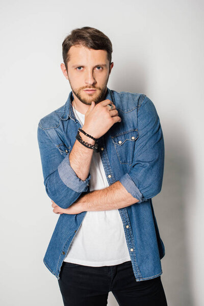 front view of handsome man in stylish clothes posing and looking at camera 