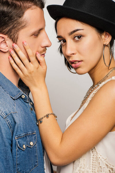 attractive girl with black hat touching cheek oh man and looking at camera 