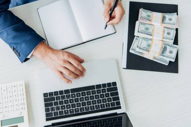 Defter ve dizüstü bilgisayar yakınlarında kalem tutan işadamı üst görünümü 