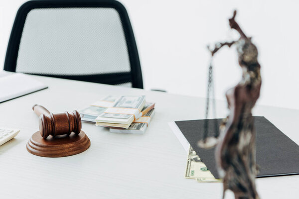 избирательный фокус денег возле молотка судьи и статуэтки правосудия
 