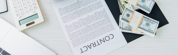 top view of contract near dollar banknotes near calculator on table 