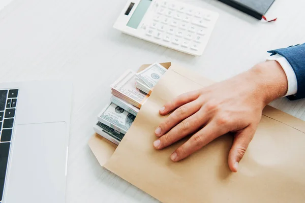 Visão Cortada Homem Colocando Mão Envelope Com Dinheiro Mesa — Fotografia de Stock