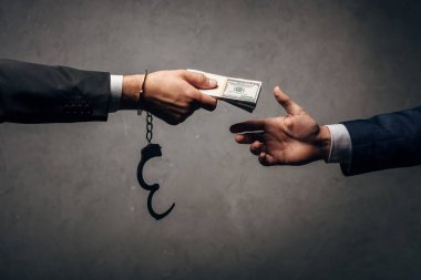 Kırpılmış Görünüm işadamı kelepçeli gri üzerinde iş ortağı rüşvet veren 
