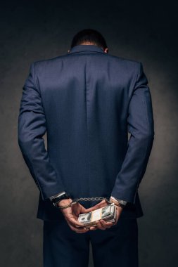 el kelepçeli adam takım elbise üzerine rüşvet gri üzerinde tutmak 