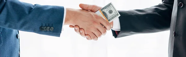 ビジネスパートナーに賄賂を与え 白で隔離された握手をする男のパノラマショット — ストック写真