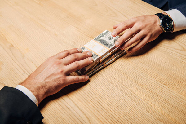 top view man giving cash to business partner near wooden table 