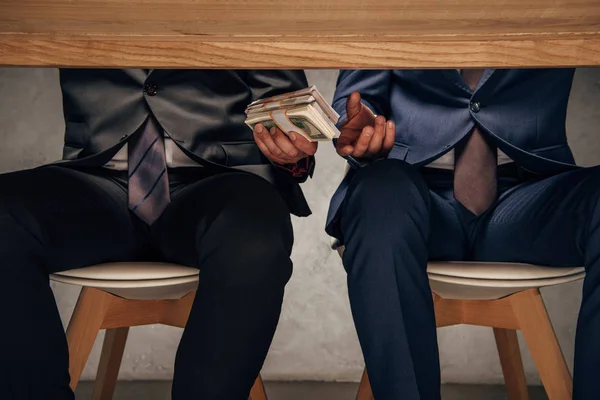 Mann Gibt Geschäftspartner Geld Während Auf Stuhl Sitzt — Stockfoto