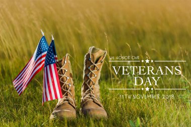 military boots near american flag with stars and stripes on grass with veterans day illustration clipart