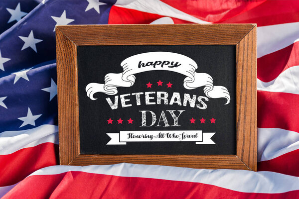 chalkboard with happy veterans day, honoring all who served illustration on american flag with stars and stripes 
