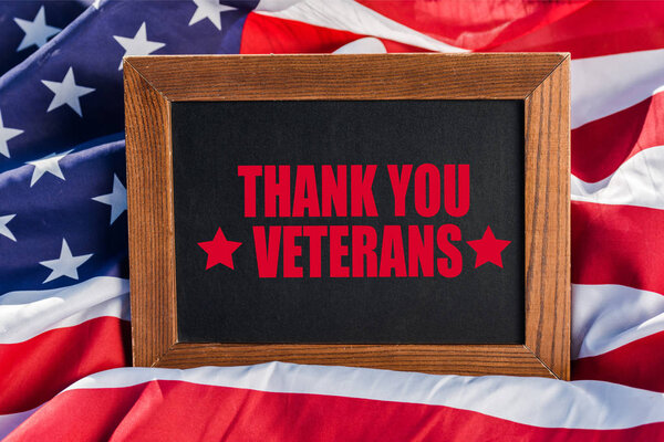 chalkboard  with thank you veterans illustration on american flag with stars and stripes 
