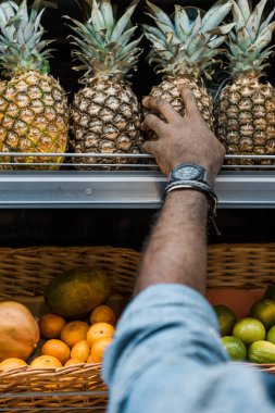 süpermarkette ananas dokunmadan afrikalı amerikalı adam kırpılmış görünümü 