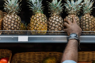 süpermarkette ananas alarak Afrikalı-Amerikalı adam kırpılmış görünümü 