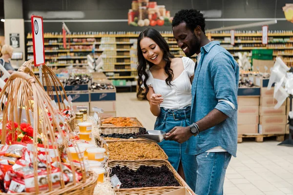 Happy African American Man Holding Metal Scoop Raisins Asian Woman — Stock Photo, Image