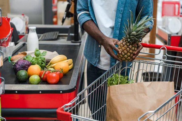Vista Cortada Homem Americano Africano Segurando Abacaxi Perto Contador Supermercado — Fotografia de Stock