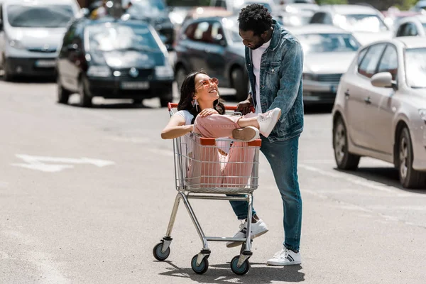 Happy African American Man Standing Asian Girl Sitting Shopping Cart — Stock Photo, Image