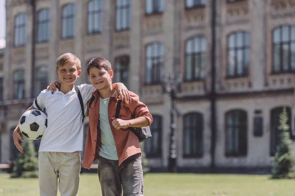 Two Cheerful Schoolboys Hugging While Standing School Soccer Ball — Stock Photo, Image