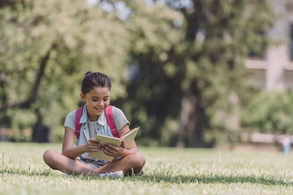 Adorable Smiling Schoolgirl Sitting Lawn Park Reading Book — Stock Photo, Image