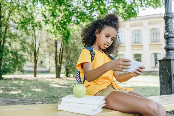 Söt Afrikansk Amerikansk Schoolgirl Sitter Bänken Nära Böcker Och Använda — Stockfoto