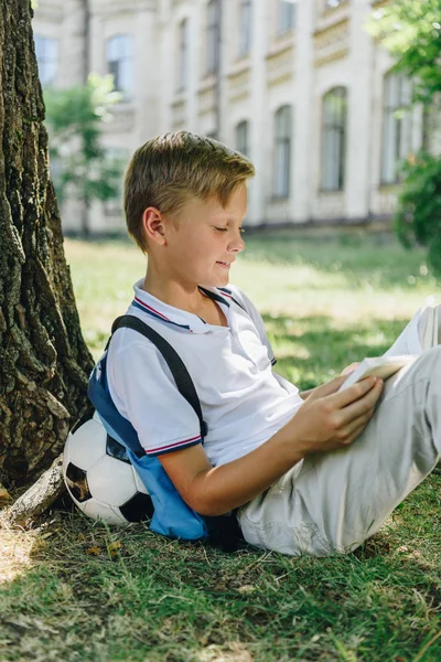 Sourire Écolier Lecture Livre Tandis Que Assis Sur Pelouse Sous — Photo