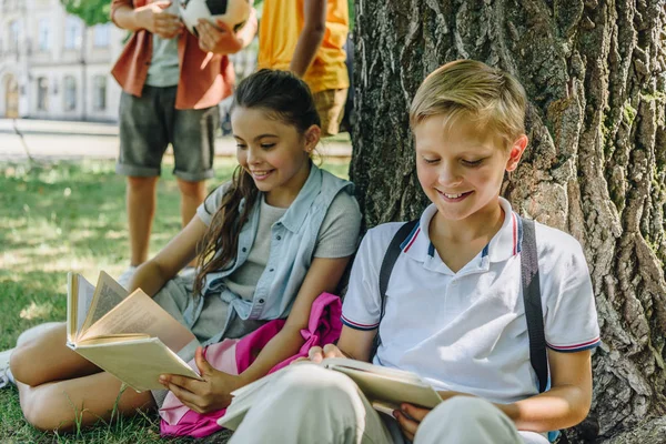 Adorable Schoolchildren Sitting Lawn Reading Books Multicultural Friends — Stock Photo, Image