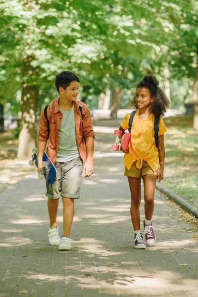 Dois Alunos Multiculturais Andando Parque Enquanto Seguram Skates — Fotografia de Stock