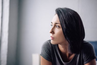 beautiful depressed woman looking away at home with copy space clipart