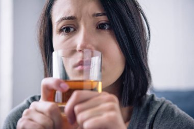 lonely depressed woman with whiskey glass at home clipart