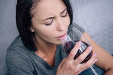 lonely upset woman drinking wine at home clipart