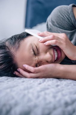 yatakta yalnız depresif kadın akıllı telefon konuşuyor ve yatak odasında ağlıyor