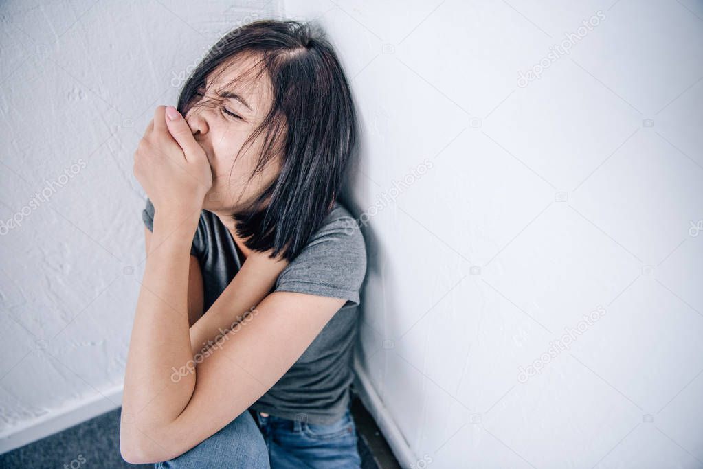 depressed brunette woman covering mouth at home with copy space