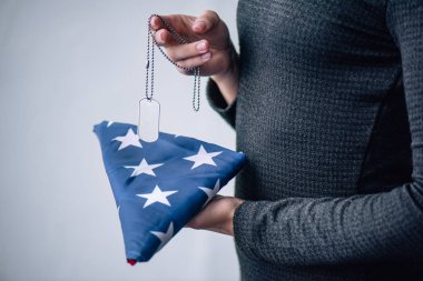 etiketi köpek tutan kadın kırpılmış görünümü ve evde katlanmış Amerikan bayrağı
