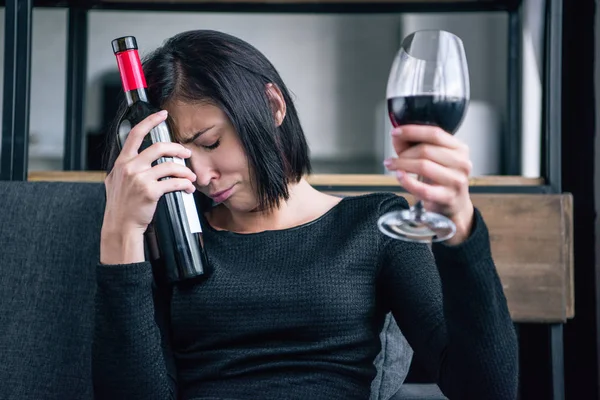 自宅でワインボトルとグラスを持つ悲しい孤独な女性 — ストック写真