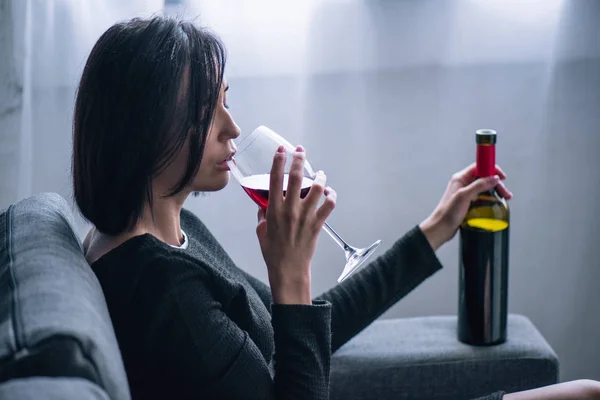 Θλιμμένη Μοναχική Γυναίκα Κάθεται Στον Καναπέ Και Πίνει Κρασί Στο — Φωτογραφία Αρχείου