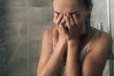 üzgün üzgün kadın yüz kapsayan ve evde duş ağlama