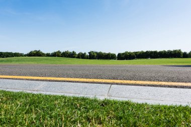 selective focus of border near yellow line  and road in summertime  clipart