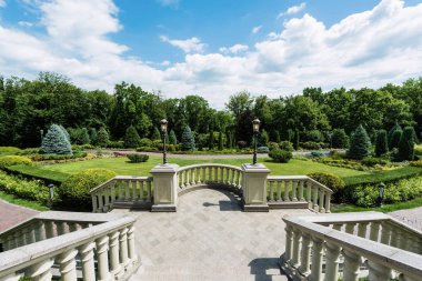 bulutlar ile mavi gökyüzüne karşı yeşil ağaçların yanında beton beyaz merdivenlerde gölgeler 