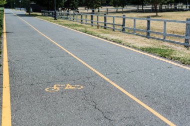çit yakınındaki gri asfalt üzerinde bisiklet şeritsarı sembolü 