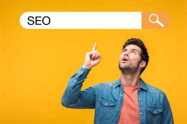 confused handsome man pointing with finger at search bar illustration with seo lettering isolated on yellow clipart