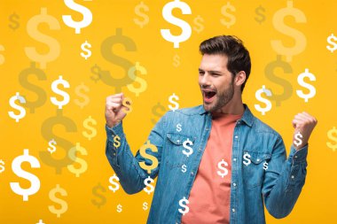 happy handsome man showing yes gesture isolated on yellow with dollars icons clipart