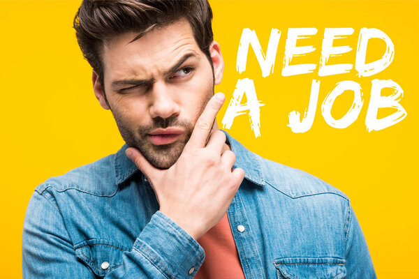 thoughtful handsome man touching chin isolated on yellow with need a job lettering
