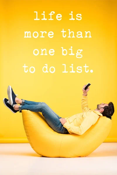 Man Relaxing Bean Bag Chair Using Smartphone Yellow Background Life — Stock Photo, Image