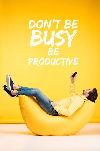 Man Relaxing Bean Bag Chair Using Smartphone Yellow Background Dont — Stock Photo, Image