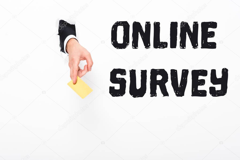 Cropped view of man holding empty business card from hole in white paper with online survey illustration