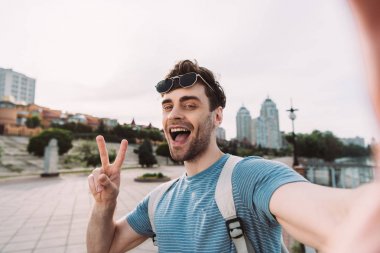 barış işareti gösteren gözlüklü yakışıklı adam ve selfie alarak 