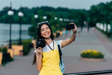  asyalı ve çekici kadın dijital kamera tutan ve selfie alarak 