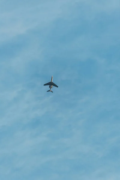bottom view of airplane flying in blue sky 