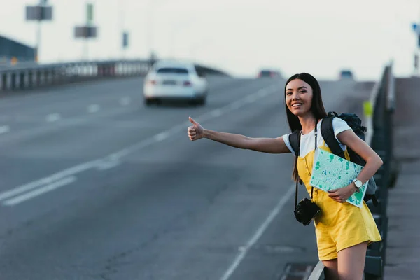 Asian Woman Yellow Overalls Hitchhiking Holding Map — Stock Photo, Image