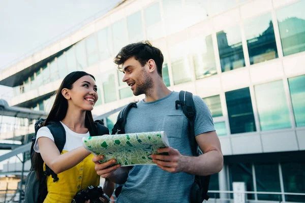 Guapo Hombre Sosteniendo Mapa Mirando Asiático Mujer — Foto de Stock