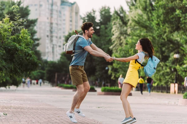 Hombre Guapo Mujer Asiática Sonriendo Saltando Tomándose Mano — Foto de Stock